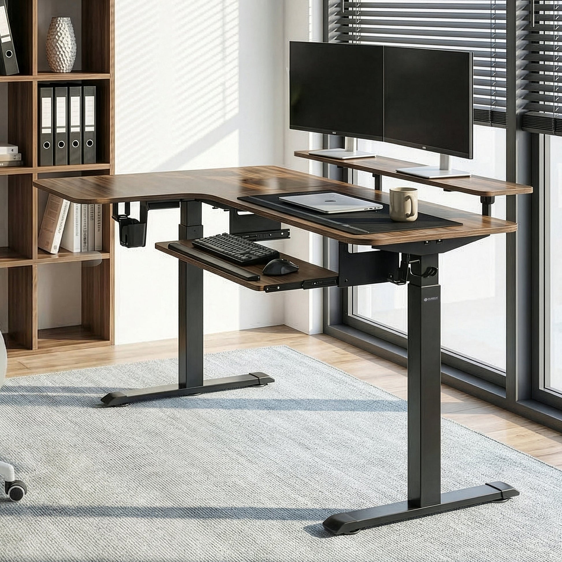 L-Shaped Standing Desk With Monitor Setup, Ergonomic Chair, and Accessories in a Home Office Setting.